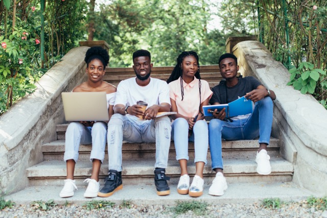 Four students sitting on the steps