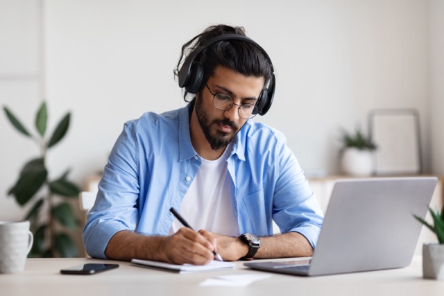 Male wearing blue shirt writing