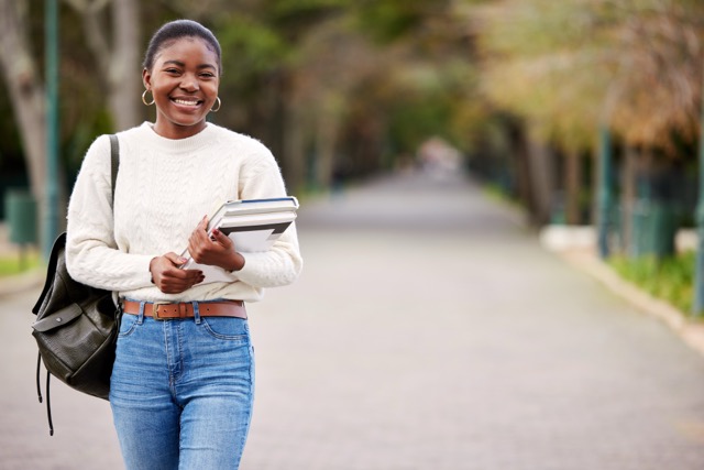 Girl holding books and smiling