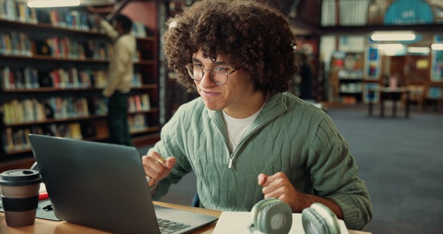 Student checking their university application status and reacting positively to an update.