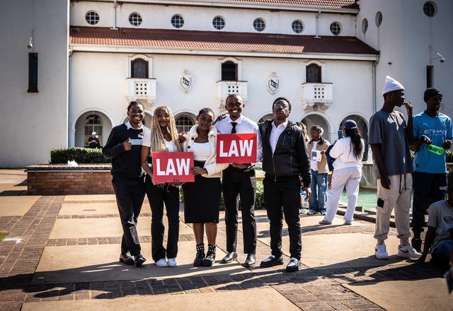 Learners holding Law sign