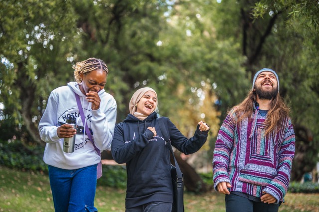 three students laughing at the park