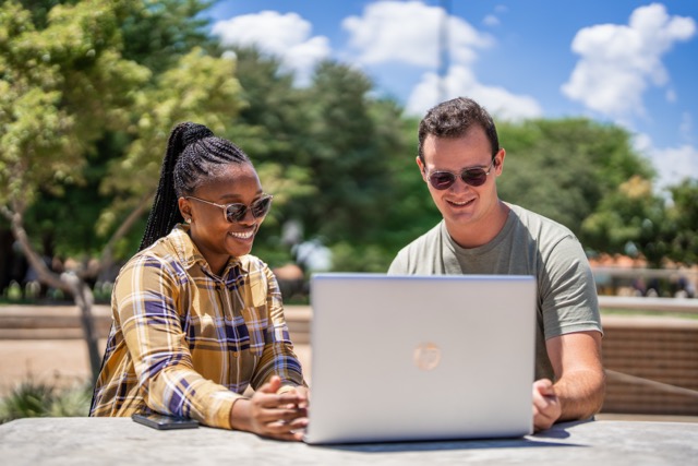 Student and lecturer looking at laptop