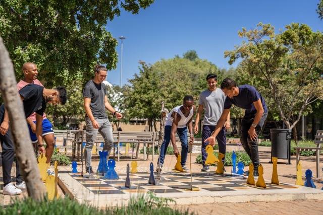 Group of friends playing outside chess