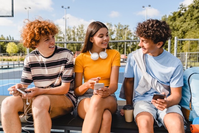 three students sitting & talking