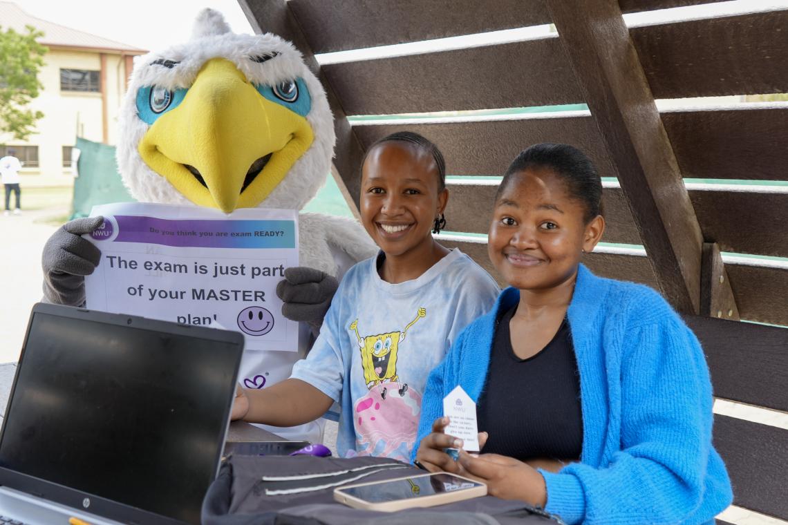 Two female students sitting with Eagi during a study session for exams
