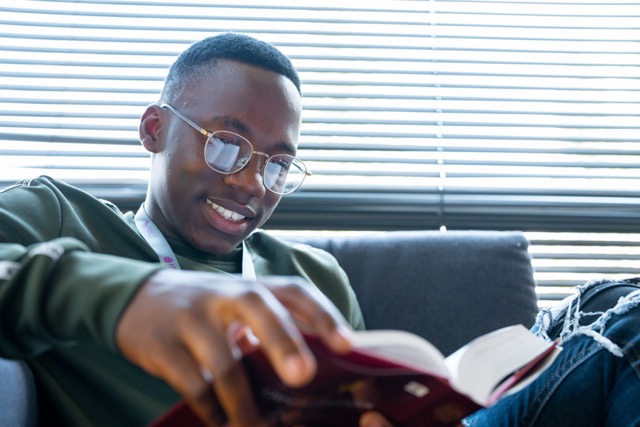 Black Distance Learner Male working on laptop