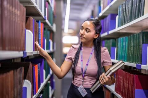 Coloured girl browing books at the library