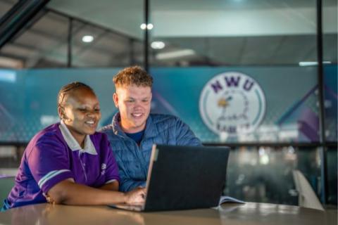 Black girl and white boy working on laptop