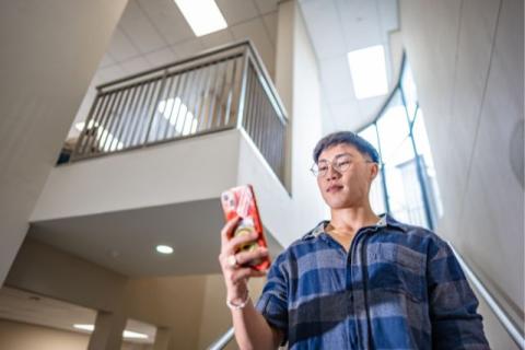 Male student interacting with mobile phone