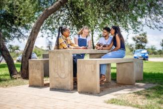 Students sitting on a bench laughing and chatting