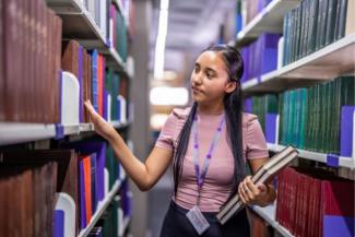 Coloured girl browing books at the library