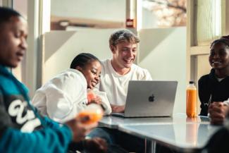 Group of students sitting around a table engaging