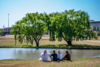 Students sitting by the Vanderbijlpark campus pond